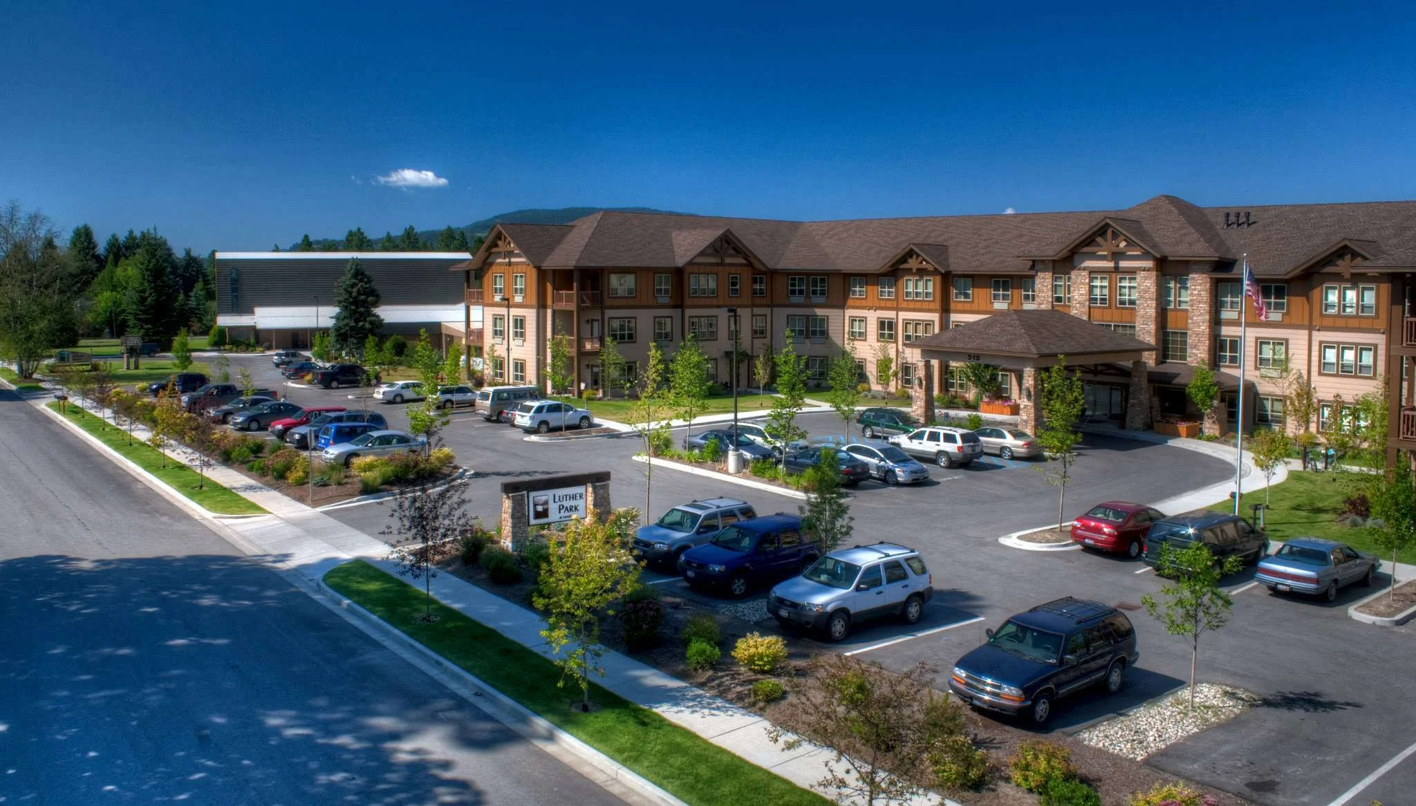 A large parking lot at the front of the main Luther Park building