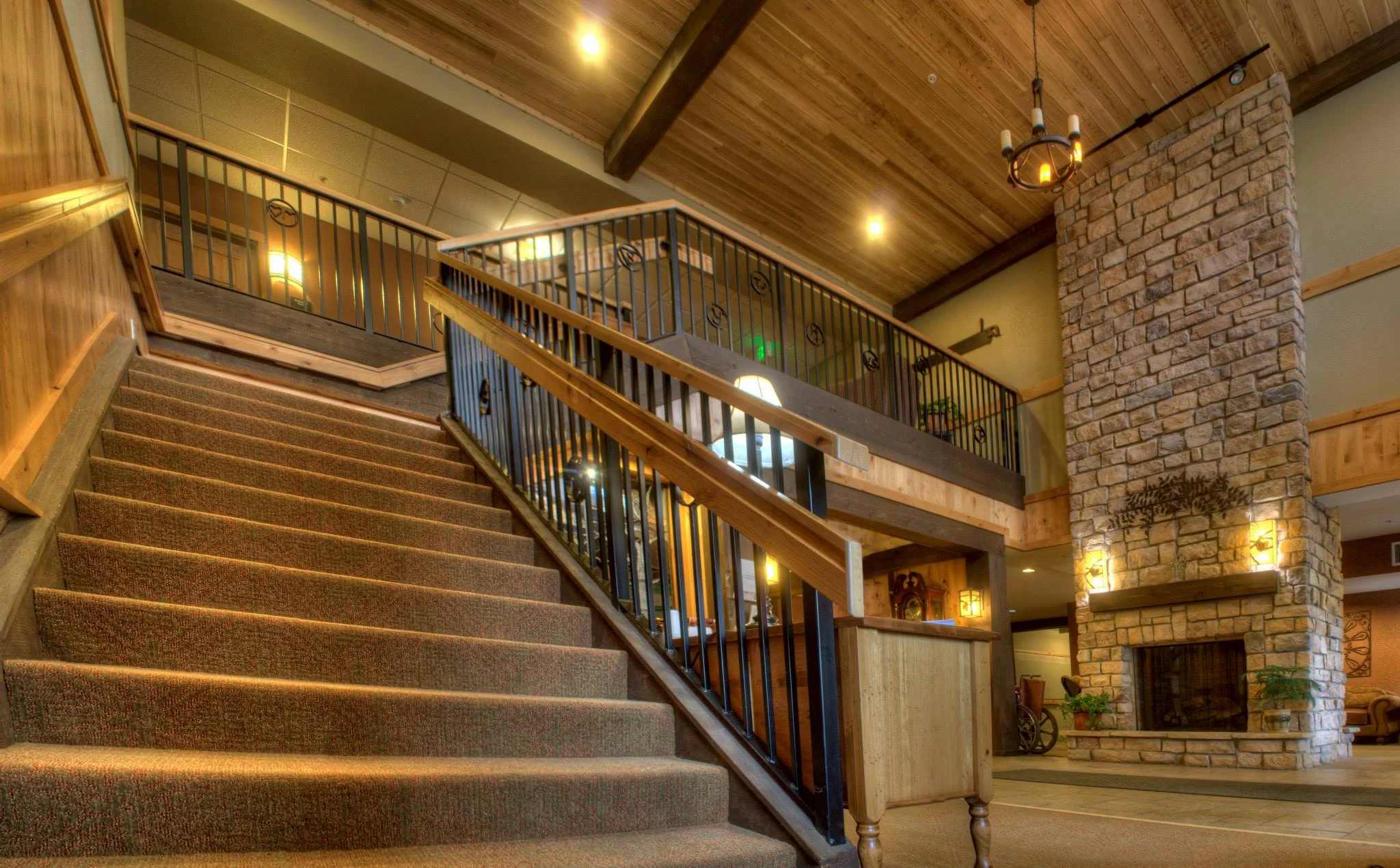 Stairs leading out of a foyer with a large fireplace