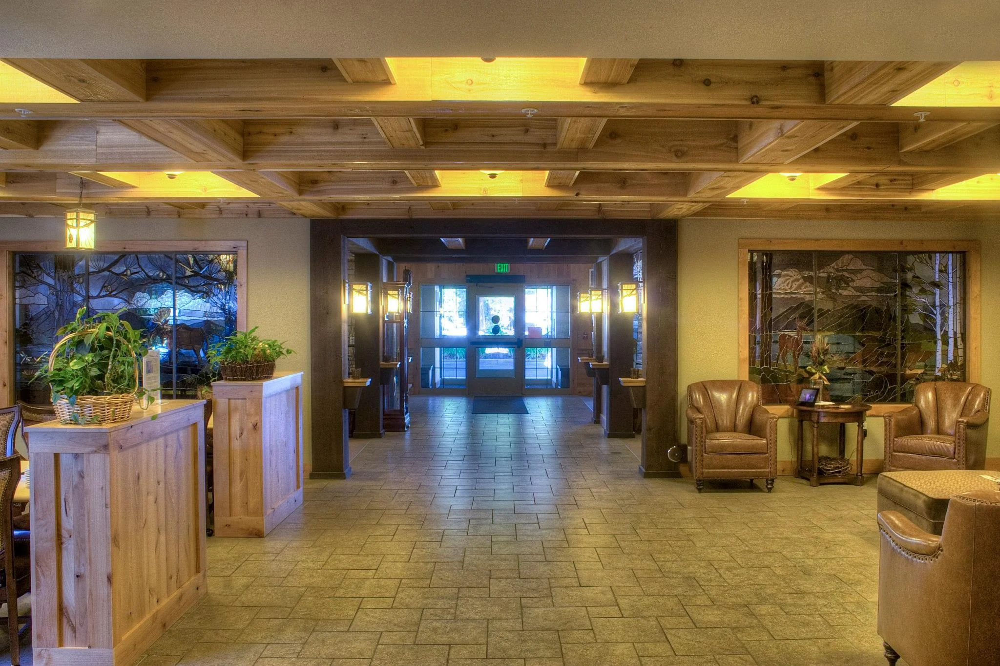 A lobby filled with armchairs, tables, and potted plants