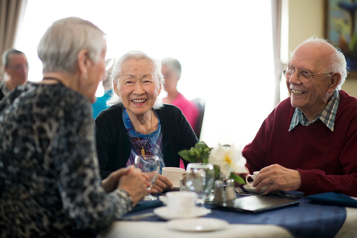 Group of seniors enjoying a conversation around a dinner table