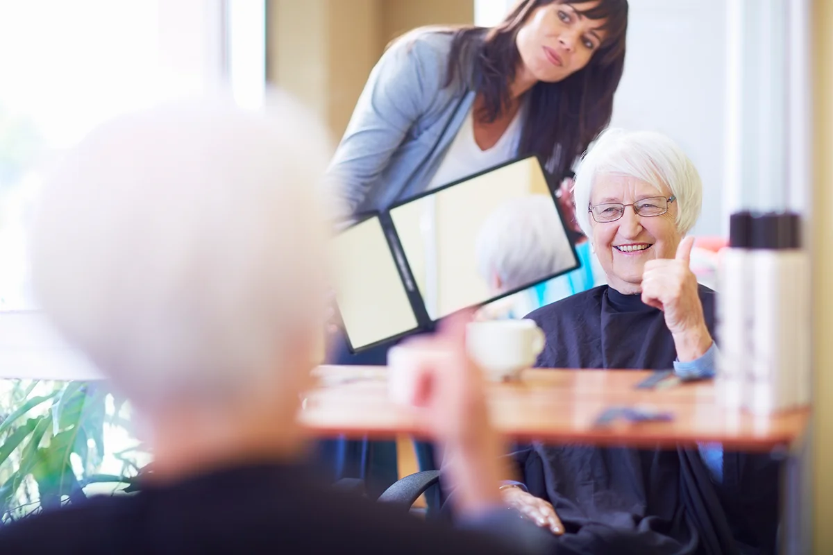 Happy senior woman admiring her new haircut in the salon