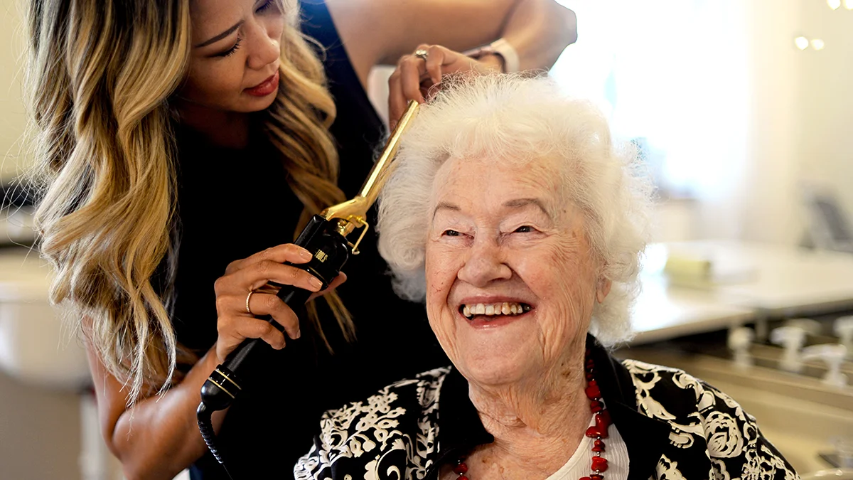 Smiling elderly woman having her hair done