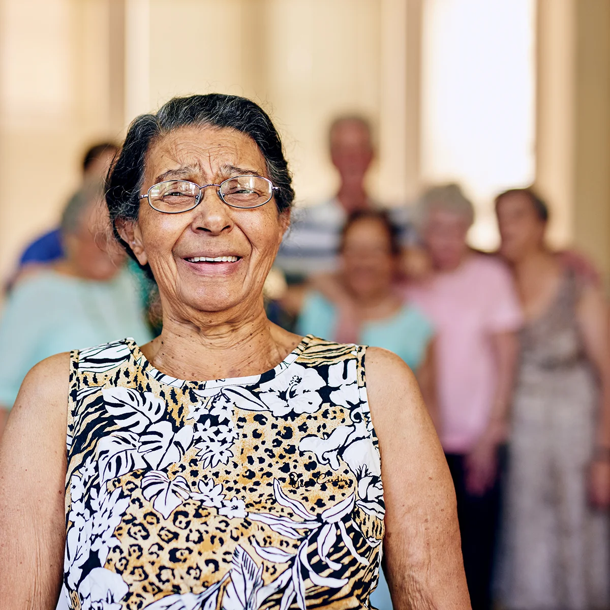 Senior woman smiling with her family behind her